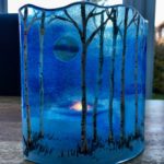 Winter birches fused glass panel with a tea light candle behind