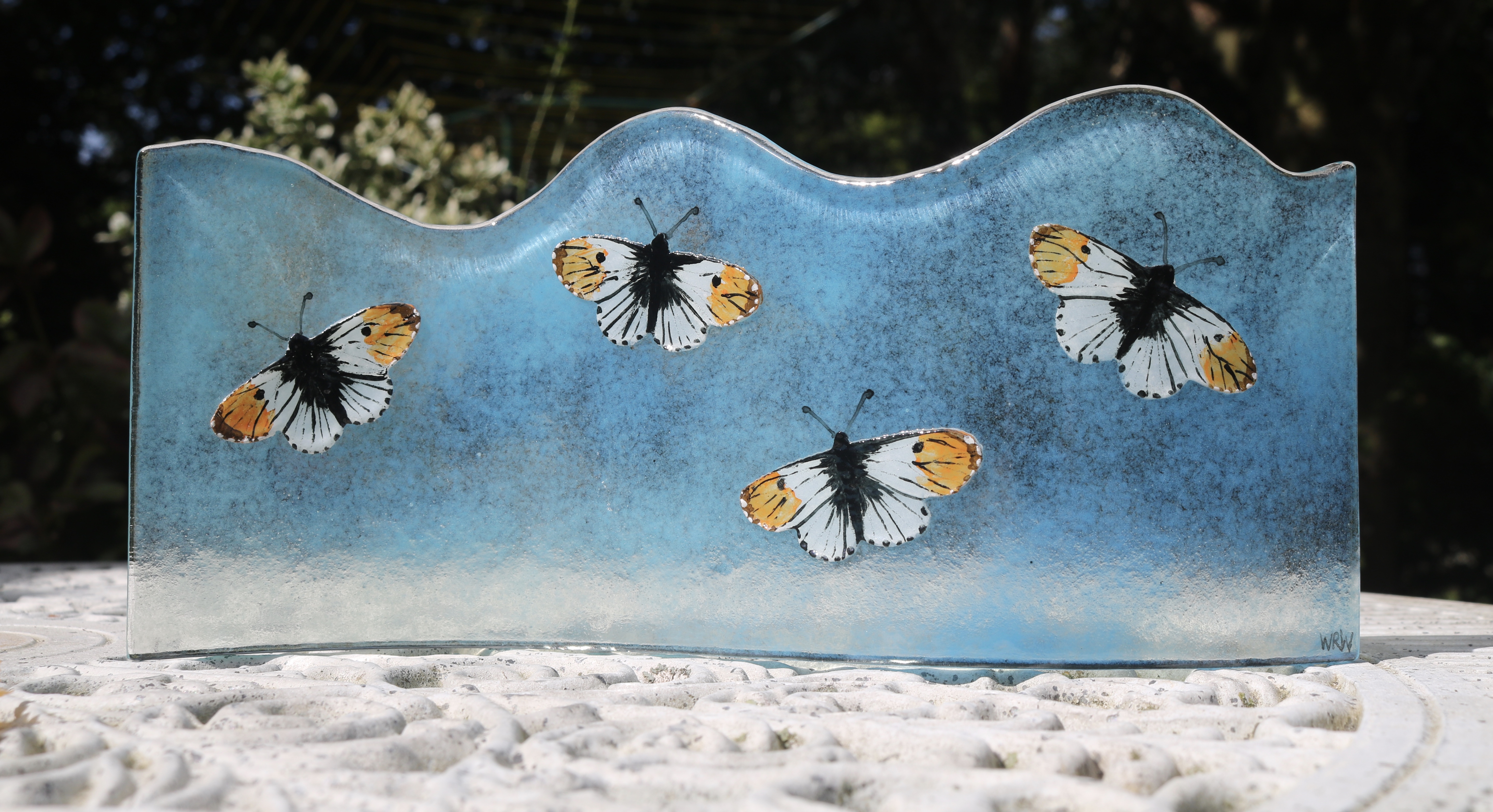 Hand painted orange tip butterflies fused to a turquoise curved glass panel