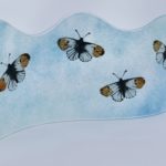Orange tip butterflies on freestanding glass art panel