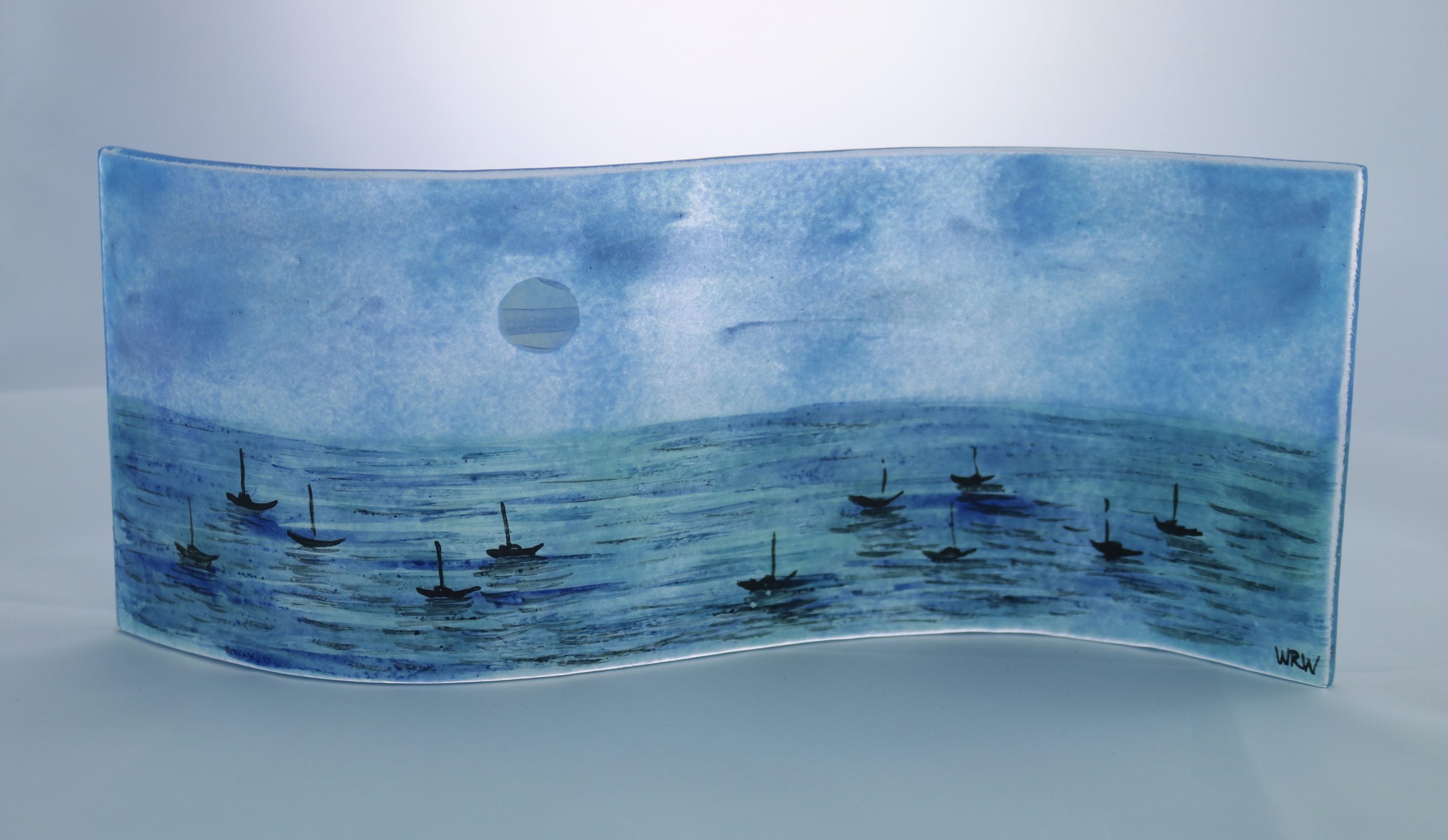 Handpainted fused glass panel with moonlit sea and silhouettes of tiny boats