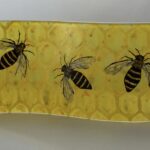 Long wavy fused glass panel of bees on a honeycomb background