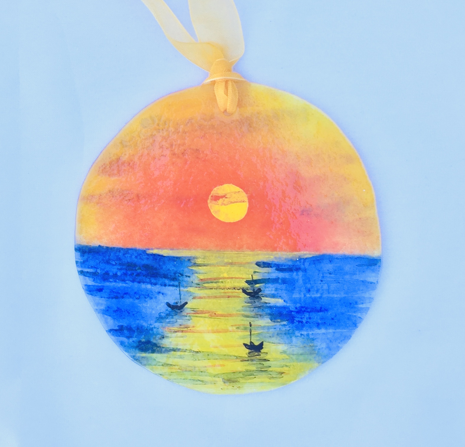 Sunset at sea suncatcher with hand-painted boats, orange sky and clear blue ocean